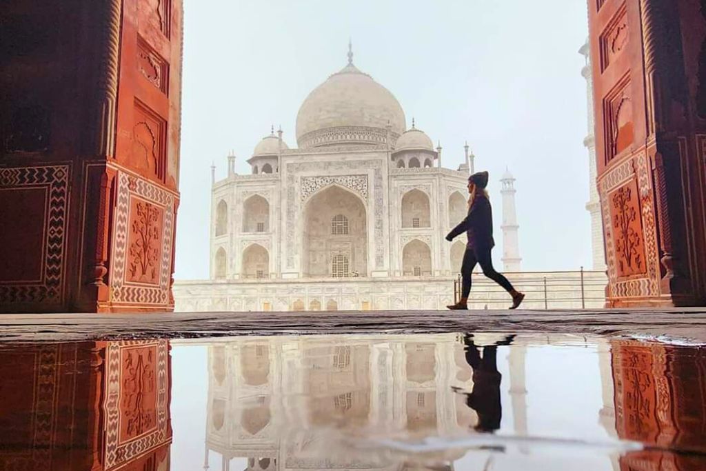 a dark figure walking in front of the Taj Mahal 